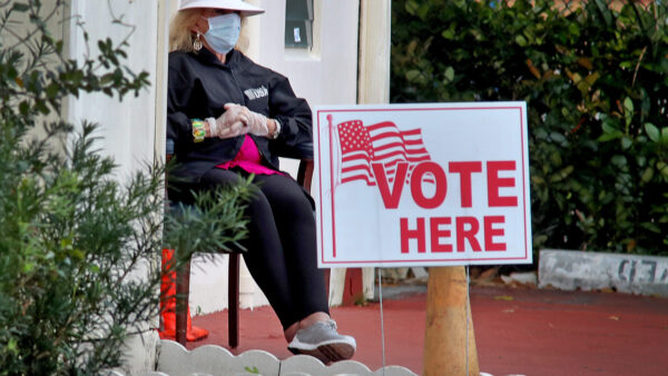 a poll worker sitting outside of a voting place