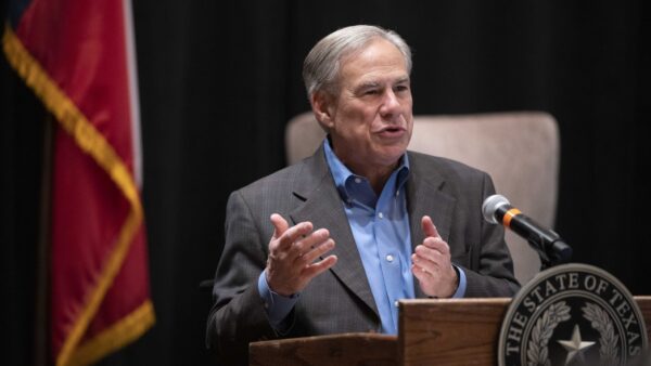 Texas Governor Greg Abbott speaks next to the American flag