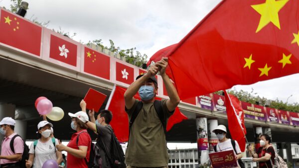 Man in waving Chinese flag at a parade.