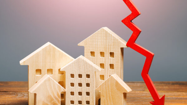 wooden houses sitting on a wooden shelf with a red arrow pointing down next to them