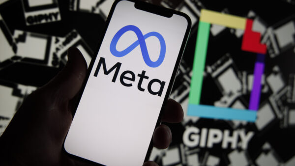 Meta logo on a phone and giphy logo in the background behind
