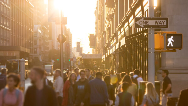 A crowd of people walk down the street in New York City