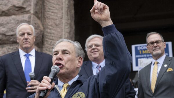 Greg Abbott speaks into a microphone
