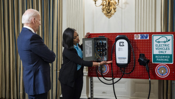 President Joe Biden watches an electric vehicle charger demonstration at the White House.