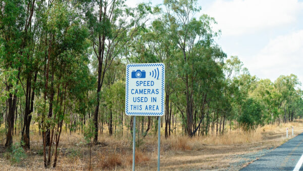 Speed camera sign on the side of the road
