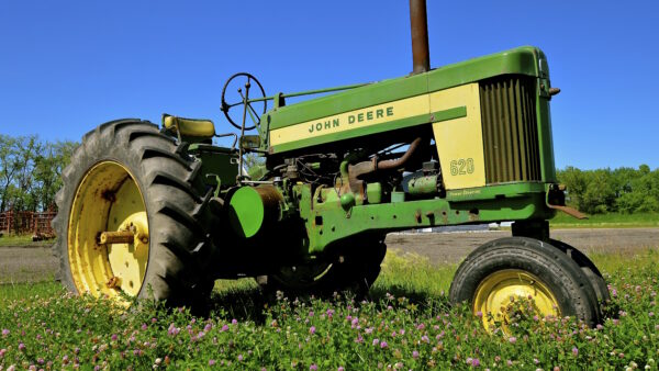 John Deere tractor parked in a field of grass