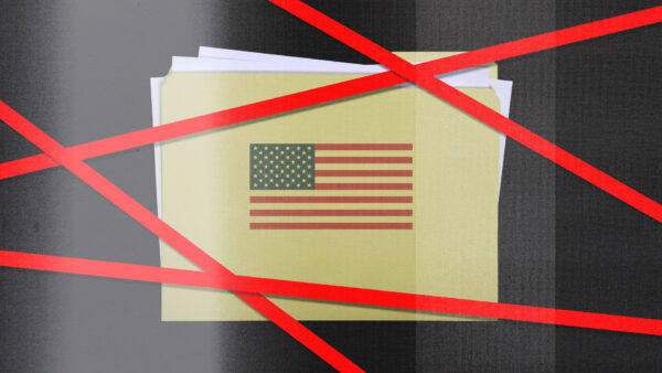 An American flag sits behind red tape
