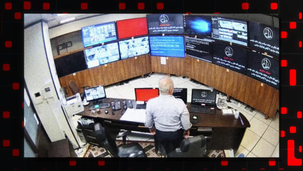 In this undated frame grab taken from video shared with The Associated Press by a self-identified hacker group called The Justice of Ali, a guard looks at surveillance screens taken over by the group, at Evin prison in Tehran, Iran.