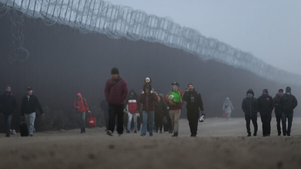 Migrants walk along the U.S.-Mexico border