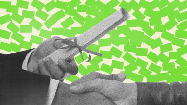 A person hands over a diploma against a backdrop of green cards