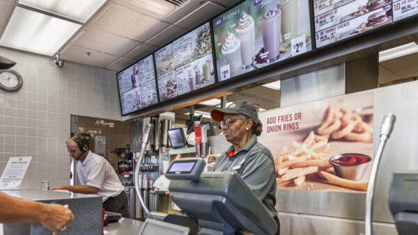 Fast food worker stands behind the counter