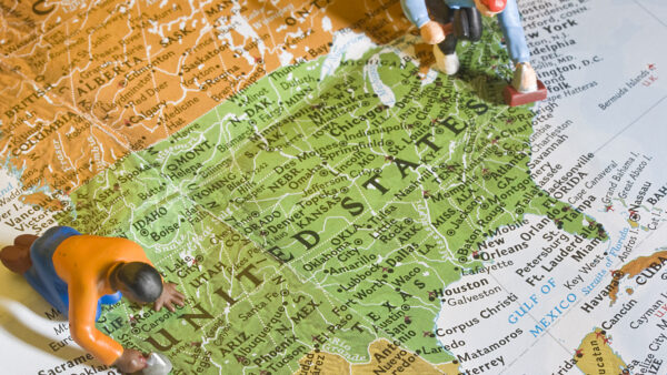 Human figurines posed as masonry workers atop a map of the United States.