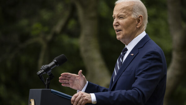Joe Biden speaking behind podium outside
