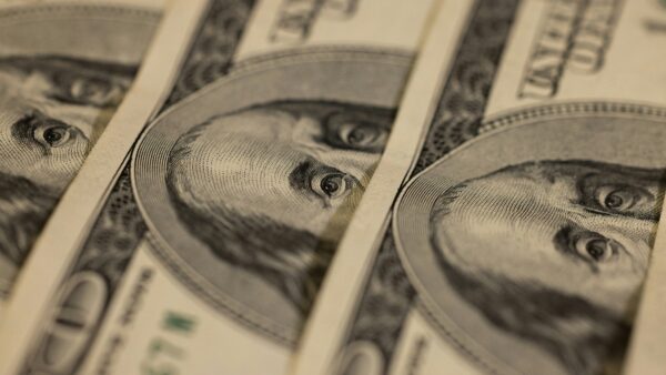 Benjamin Franklin's face appears amid a stack of American $100 bills