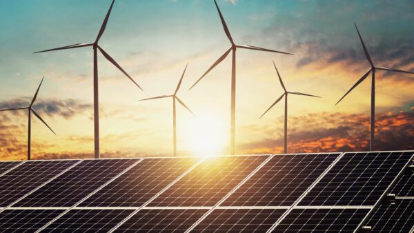 Wind turbines seen behind a solar panel