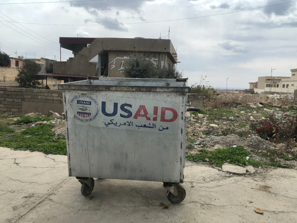 A dumpster captioned "USAID: from the American people" in Iraq. | Matthew Petti